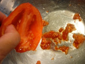 5. Cut tomatoes in half.  Scoop out the seeds trim the stem end.  Your tomatoes are now ready to use! 