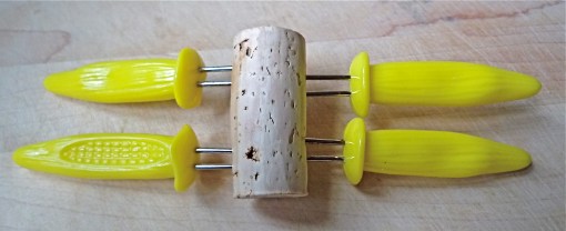 Organize sharp objects like corn cob holders and push pins with a cork